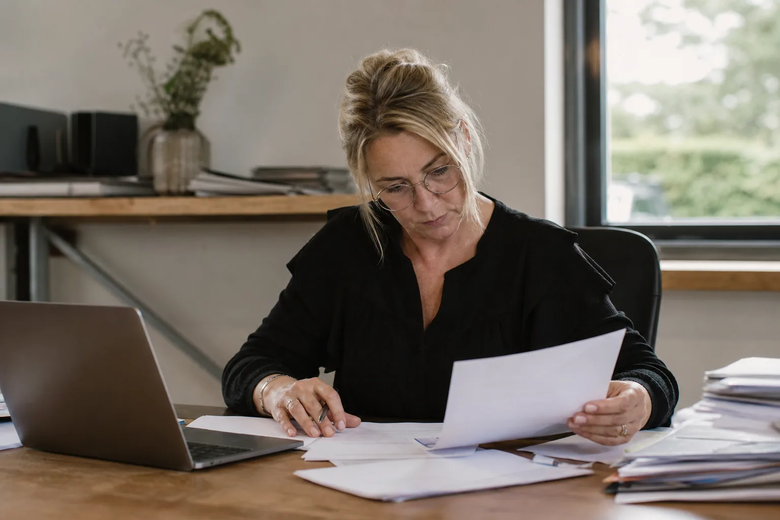 Administratief werk op een klein Nederlands kantoor. Beeld bij het artikel: Wat moet er op je factuur staan zodat een klant geen excuus heeft om later te betalen?